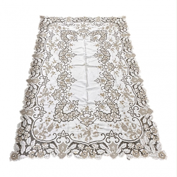 Toalha de mesa em linho com rico trabalho em renda Richelieu e bordados em motivos florais, medindo 233 x 160 cm; apresenta acabamento vazado, discretas manchas, vincos de armazenamento, sinais de uso