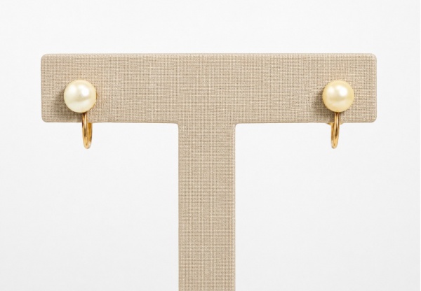 Par de brincos em ouro amarelo 18k, com fecho de rosca, adornados por pérolas cultivadas em formato gota. Peças de desenho clássico e elegante. Peso: 2,8 g.