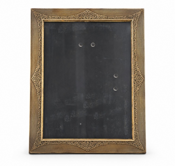 Porta-retrato 16 x 21 em prata de lei teor 800, de formato retangular, com rica decoração gravada em motivos florais e arabescos em relevo. Acompanha vidro frontal e suporte traseiro. Apresenta sinais