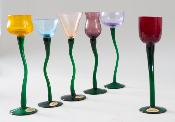 Conjunto com 6 taças em vidro artístico Bayern, com bojos em cores variadas e hastes verdes de formato ondulado, a maior medindo 19 cm de altura, apresentando bicados, desgates e marcas de uso.