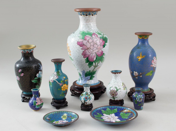 Lote composto por 8 miniaturas de vasos em metal com decoração em esmalte cloisonné policromado e 2 pires,ornamentados com motivos florais, aves e padrões orientais, acompanhados de bases de madeira,