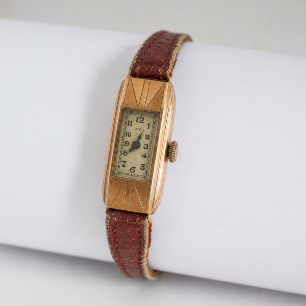 Relógio de pulso feminino, marca ATIC, caixa retangular alongada em ouro 18 quilates (750/1000, contraste 18K visível no verso), linhas geométricas em relevo características do estilo Art Déco, mostra