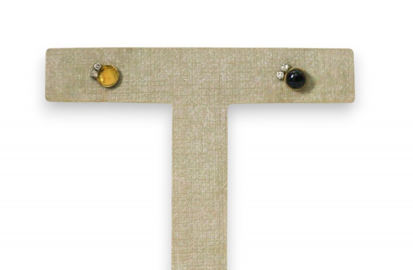 Par de brincos em ouro 18 k, modelo de botão com detalhe em pedra esférica negra e pequeno aplique de pedras incolores, pesando 1,6 g, faltando uma das esferas em um dos brincos e apresentando sinais 