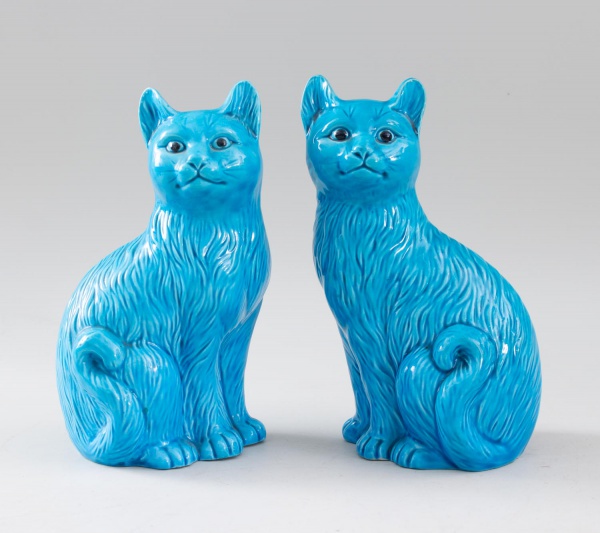 Par de esculturas decorativas em porcelana esmaltada azul, representando gatos sentados, fabricação chinesa, medindo 20 cm de altura cada, com marcas do tempo.