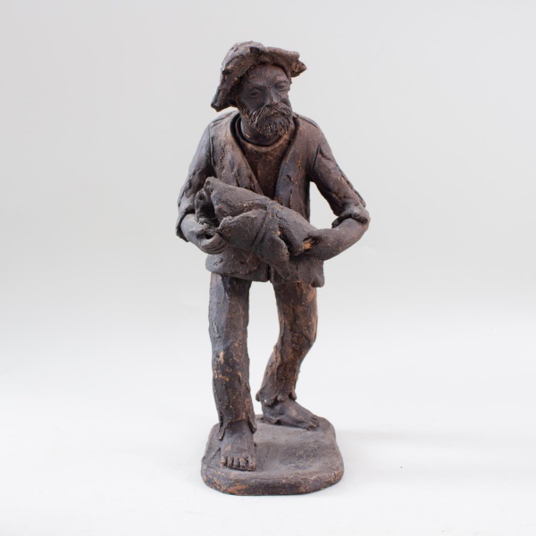 Escultura em barro representando trabalhador rural carregando recipiente nos braços, sobre base integrada, assinada Zé do Carmo; altura: 34 cm; apresenta marcas do tempo e desgastes naturais.