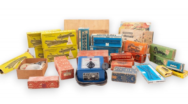 Lote composto por peças e acessórios para ferromodelismo da marca Märklin, incluindo controlador de velocidade, vagões, caixas originais, trilhos, cruzamentos, ponte metálica, fios e acessórios divers