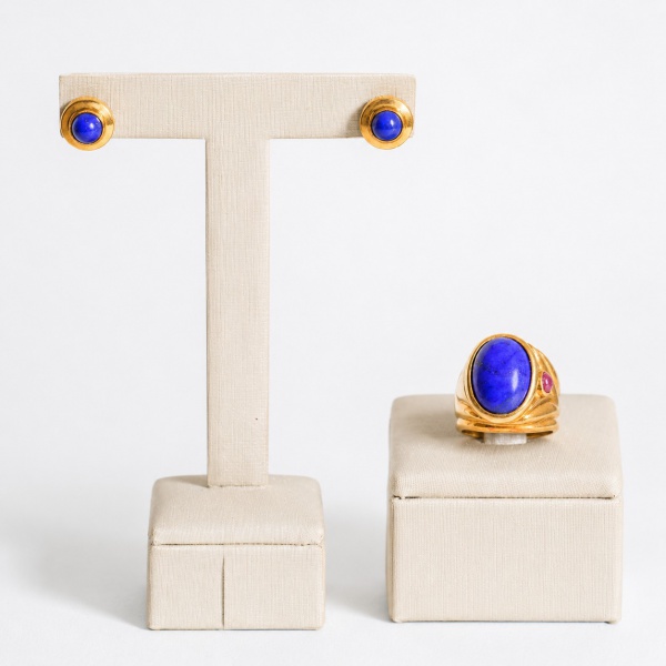 Conjunto em ouro 18K composto por anel e par de brincos de pressão (clip), em desenho escultórico canelado/ondulado, cada peça centralizada por cabochão oval de lápis-lazúli de tonalidade azul intensa
