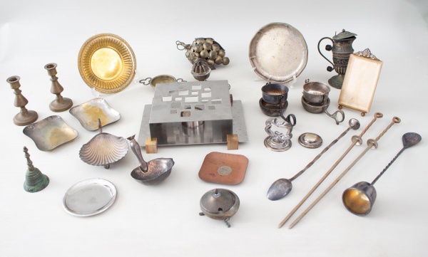 Lote composto por 26 peças, sendo objetos decorativos e utilitários em metal prateado, estanho e inox, incluindo castiçais, travessas, suportes, porta-velas, miniaturas, peças diversas e um rechaud em