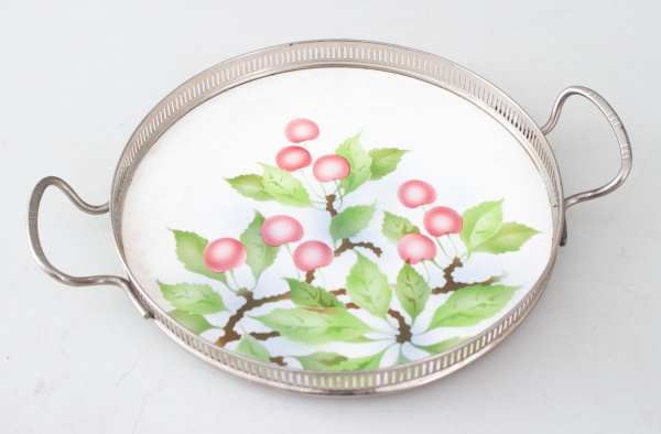 Bandeja redonda em porcelana Boozen, com decoração de cerejas e estrutura com galerias e alças em metal. Medindo 30 cm de diâmetro. Apresenta marcas do tempo e leves desgastes compatíveis com a conser