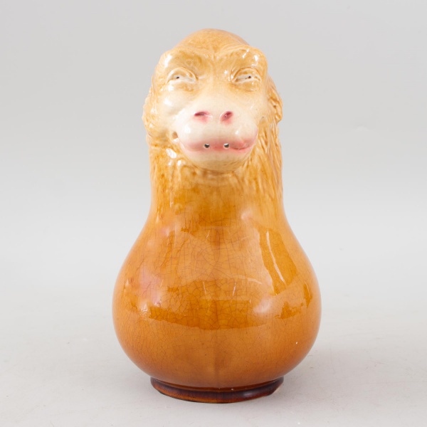 Jarra em cerâmica Majolica francesa, manufatura Sarreguemines, modelada em forma de cabeça de carneiro com rica decoração em relevo e esmaltação craquelada em tons ocres, peça de caráter ornamental e 