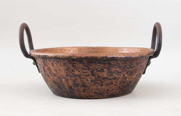 Tacho em cobre martelado de formato oval, com alças laterais em ferro forjado, destacando acabamento artesanal e pátina natural do tempo. Medindo 34 cm de diâmetro e 19 cm de altura, apresenta marcas