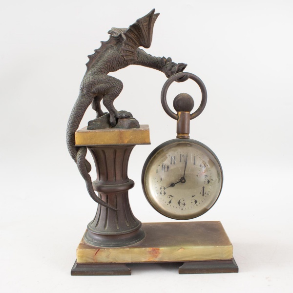 Relógio de mesa francês antigo, com estrutura em bronze representando dragão sustentando esfera de vidro contendo o mecanismo do relógio, montado sobre coluna e base em mármore de influência Art Nouve