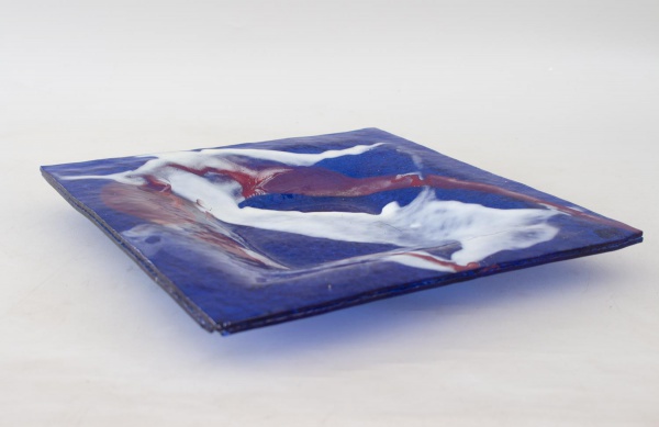 Centro de mesa em vidro artístico de formato quadrado, decorado em composição abstrata nas tonalidades azul, branco e vinho, medindo 30 x 30 cm, apresentando bicados, desgastes e marcas de uso.