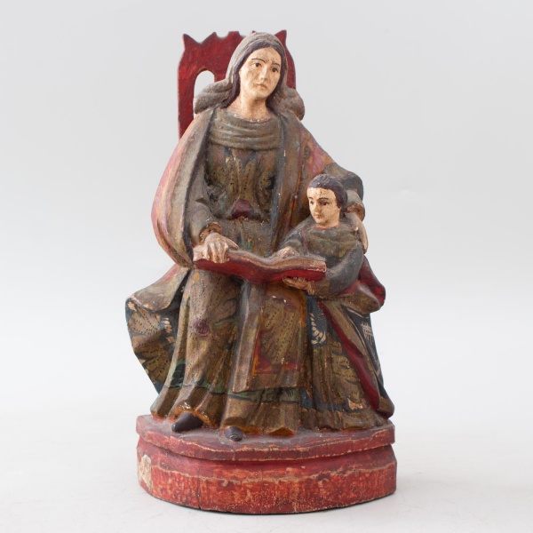 Escultura sacra representando SantAna Mestra com a Virgem Maria criança, em madeira entalhada e policromada, sobre base e espaldar vazado, medindo 25 cm de altura, apresentando desgastes na policromia