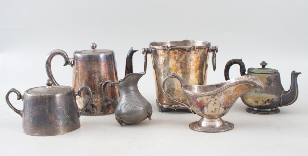 Lote composto por seis peças em metal, diversas procedências, século XX. Compreende dois bules, açucareiro com tampa, pequena jarra em estanho, molheira e balde para gelo com alças laterais em argola.