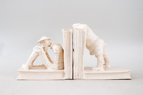 Par de aparadores de livros em cerâmica craquelê esmaltada, modelados com figuras de camponeses em cenas rurais, de caráter decorativo. Altura do maior: 17 cm. Apresentam craquelado de fabricação, alé
