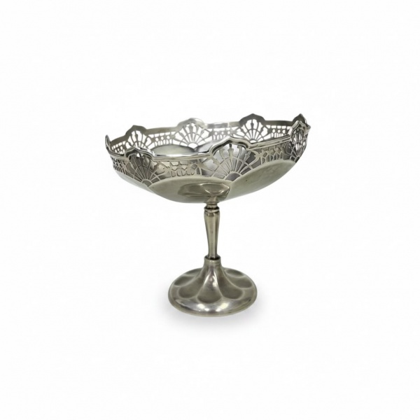 Centro de mesa em prata de lei, teor 925, de corpo elevado sobre pé circular e borda vazada com decoração geométrica em estilo Art Déco. Altura: 12 cm. Peso: 132 g. Apresenta marcas de uso,desgastes e