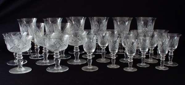 Lote com 25 taças em cristal incolor do mesmo modelo, com decoração lapidada, em tamanhos variados. Altura da maior: 16 cm. O conjunto apresenta bicados, além de marcas de uso e desgastes compatíveis