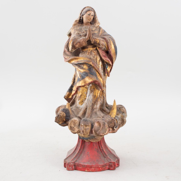 Escultura sacra representando Nossa Senhora da Conceição, em madeira entalhada e policromada com vestígios de douração, apoiada sobre base com nuvens, cabeças de querubins e lua crescente. Altura: 31