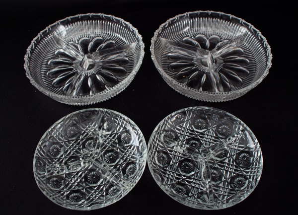 Lote com 4 petisqueiras em vidro prensado incolor, sendo duas circulares tripartidas e duas menores com decoração geométrica em relevo. Medida da maior: 20 x 20 cm. Apresentam marcas de uso e desgaste