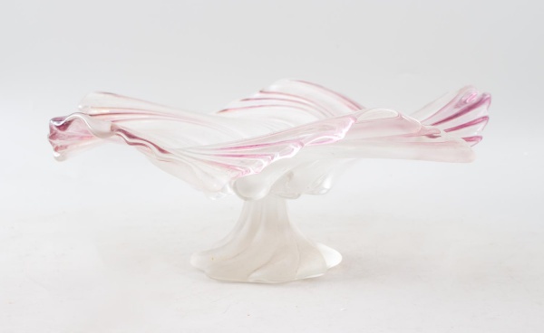 Centro de mesa em vidro artístico opalino, de corpo em movimento espiralado com bordas onduladas em tonalidade rosada e base central estilizada. Altura: 16 cm. Apresenta marcas de uso e desgastes comp
