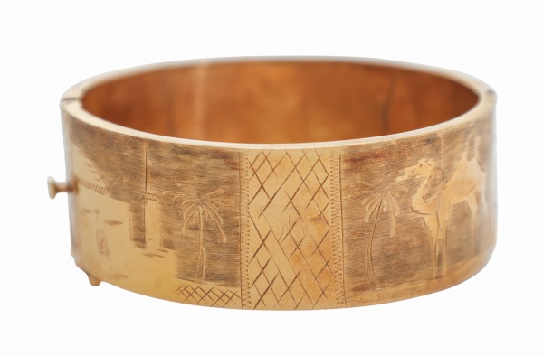 Bracelete rígido em ouro 16 k; modelo articulado com abertura frontal e fecho de segurança; corpo largo com decoração em gravações geométricas; acabamento polido; peso 18,1g; apresenta sinais de uso,