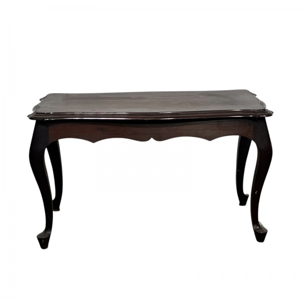 Mesa de centro em madeira com tampo retangular de bordas recortadas e saia decorada, apoiada sobre quatro pernas cabriolet, medindo 45 cm de altura, 80 cm de comprimento e 41 cm de largura, em estado