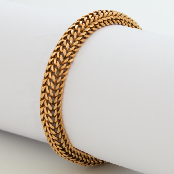 Pulseira em ouro 16K, com malha articulada de padrão entrelaçado, apresentando fecho tipo caixa com trava de segurança; comprimento aberto 21 cm; peso 36,7 g; em bom estado geral