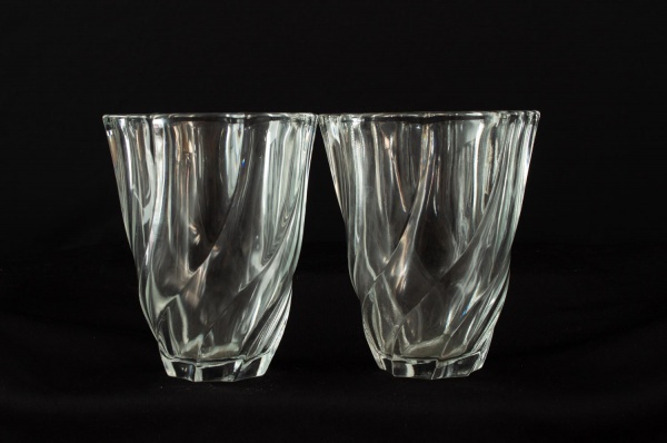 Par de vasos em cristal moldado francês, marca France, de corpo facetado com torção helicoidal e borda recortada, medindo 13 cm de altura, apresentando marcas do tempo.
