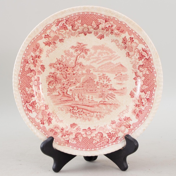 Prato em faiança inglesa Woods Burslem, padrão Seaforth, decorado em tonalidade vinho com cena oriental e borda floral, medindo 26 cm de diâmetro, apresentando craquelê de esmalte e marcas de uso comp
