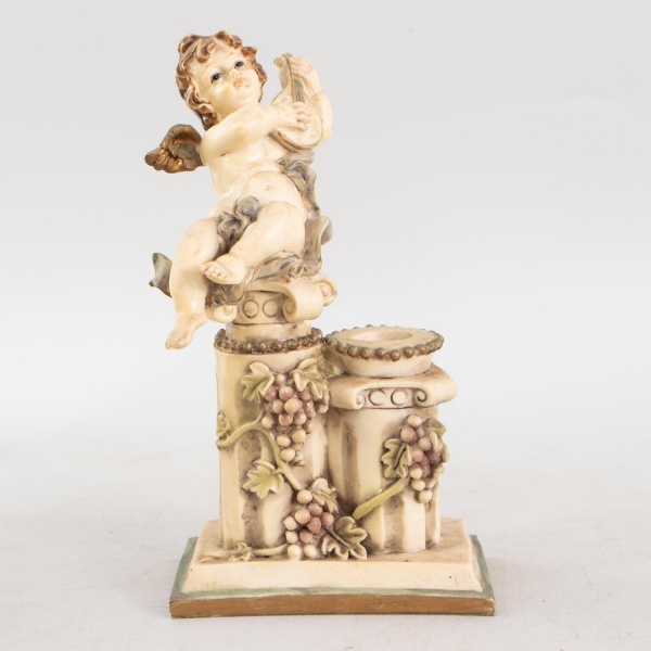 Estatueta vintage italiana Fontanini Depose, em resina policromada, representando querubim alado tocando bandolim sobre pedestal decorado com cachos de uvas, com castiçal integrado, medindo 19 cm de a