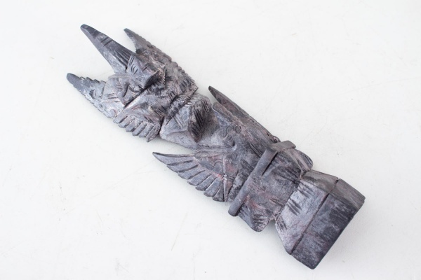 Escultura em madeira entalhada, de origem indonésia (Bali), representando Garuda, entidade mitológica amplamente venerada na Ásia, com rica decoração esculpida em relevo e acabamento em pátina escura,