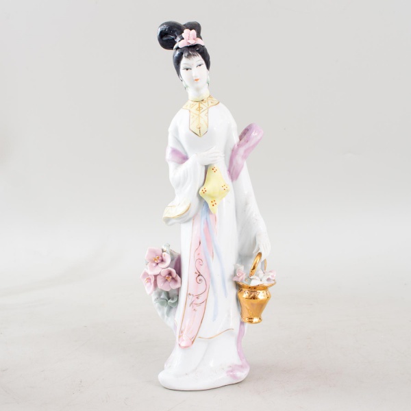 Escultura chinesa em porcelana policromada, representando dama da corte trajando hanfu estilizado, com penteado em coque adornado, portando vaso de flores e rica decoração em esmaltes policromos com d