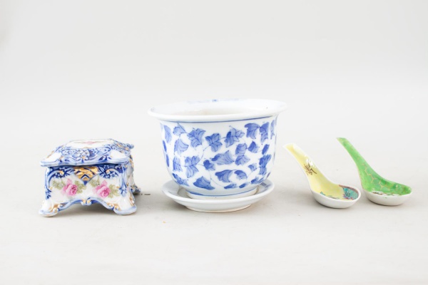 Lote composto por 4 peças em porcelana oriental, sendo um cachepô decorativo, uma caixa com tampa e duas colheres de apoio em porcelana policromada, com decorações florais e orientais, medindo a maior
