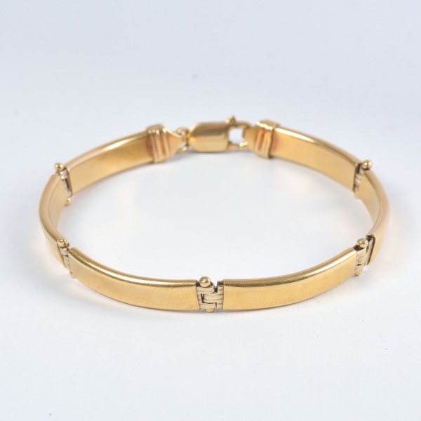 Pulseira articulada em ouro 18K, peso 12,9 g, com diâmetro maior de 6,5 cm e menor de 6 cm. Modelo rígido composto por segmentos lisos interligados, acabamento polido e fecho tipo lingueta com trava d