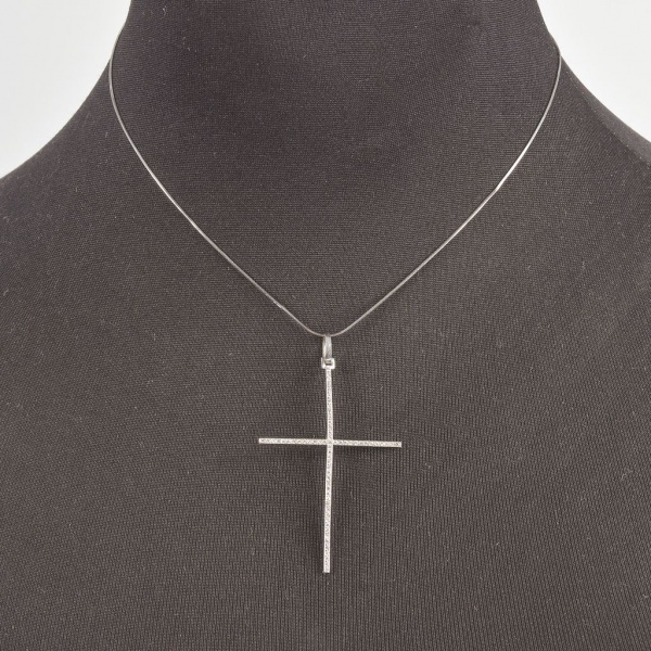 Crucifixo em ouro branco 750 com corrente em malha tipo rabo de rato. O pingente apresenta design minimalista em forma de cruz, com hastes finas cravejadas por pequenos brilhantes Comprimento aberto d