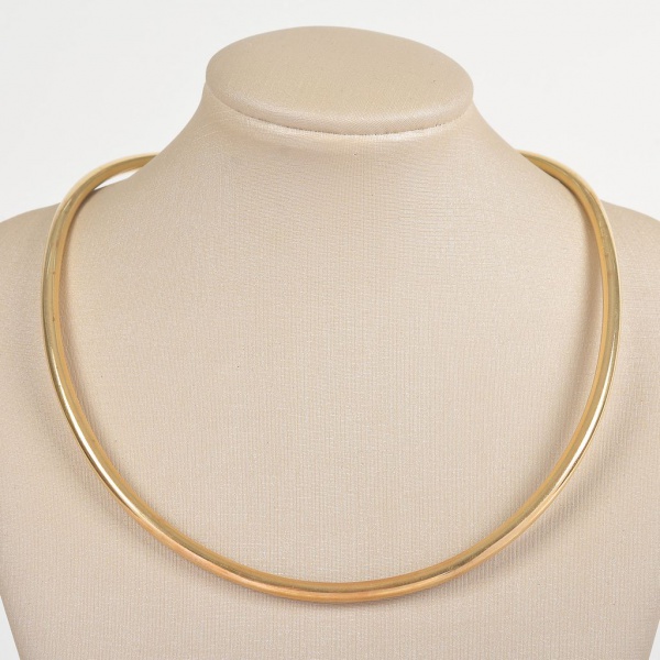 Gargantilha rígida em ouro amarelo 18K, peso: 27,3 g. Peça de design clássico e elegante, com estrutura levemente ovalada e fechamento discreto, ideal para uso solo ou com pingente.
