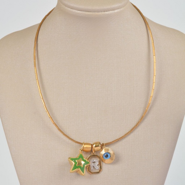 Gargantilha em ouro amarelo 18K com três pingentes: medalha com letra R em ouro branco, esfera polida e estrela esmaltada em verde. Peso total: 11,2 g. Peça delicada e moderna, ideal para uso cotidian