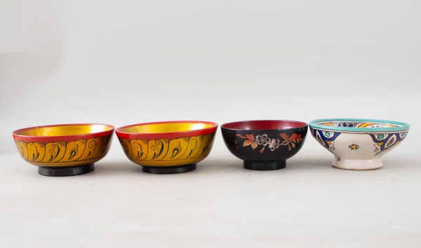 Lote composto por 4 tigelas decorativas, sendo 3 em madeira pintada à mão e 1 em cerâmica esmaltada e pintada à mão, com decoração policromada, apresentando marcas de uso e conservação compatíveis com