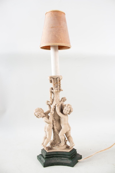 Lote composto por abajur de mesa com coluna ornamentada por figuras de querubins em relevo sobre base sextavada, acompanhado de cúpula, medindo 60 cm de altura, 19 cm de largura e 15 cm de profundidad