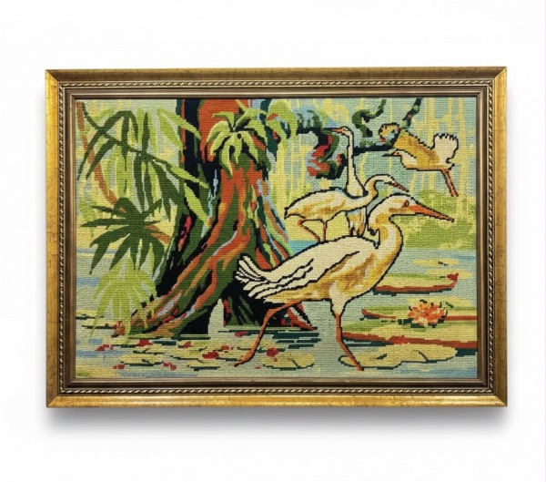 Quadro em tapeçaria artesanal representando garças em paisagem lacustre, ricamente confeccionado em fios policromados e acondicionado em elegante moldura de madeira patinada em dourado, medindo 108 x
