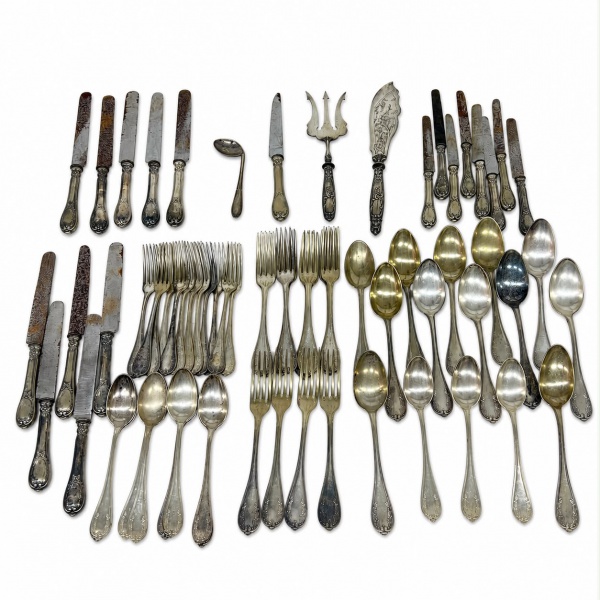 Lote composto por 70 peças de talheres e utensílios de servir em metal, incluindo facas, garfos, colheres e peças de servir de diferentes modelos e padrões decorativos, vendido no estado, com sinais d