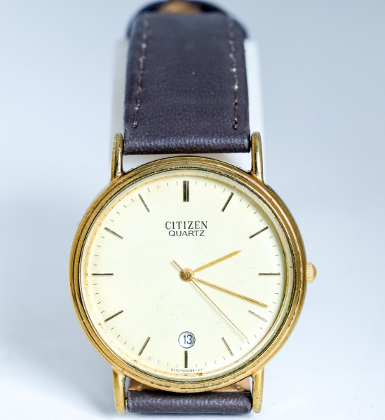 Relógio de pulso Citizen Quartz, original, movimento a quartzo japonês, caixa em metal dourado com fundo em aço inox, mostrador dourado com calendário na posição das 6 horas e pulseira em couro, testa