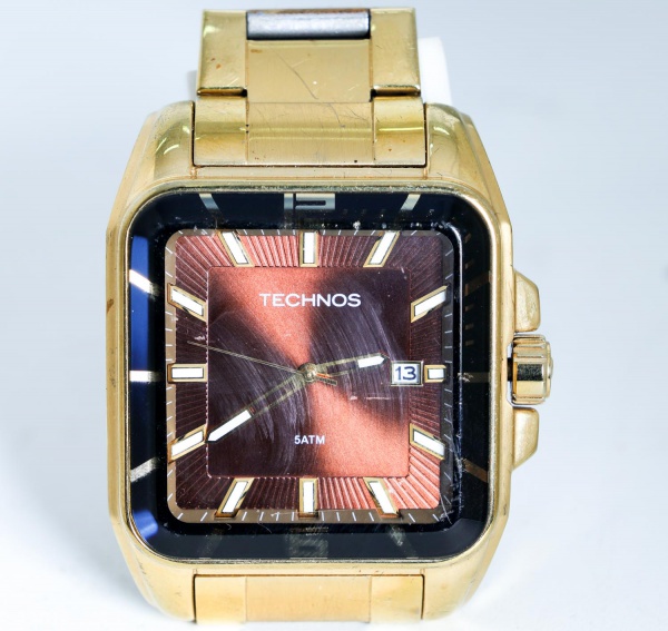 Relógio de pulso masculino Technos, original, com caixa e pulseira em aço inox com acabamento dourado e detalhes centrais em aço, mostrador marrom com calendário, resistência à água de 5 ATM, modelo 2