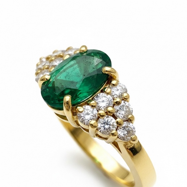 Anel em ouro amarelo 18k (750), pesando aproximadamente 7,34 g aro:17 . Apresenta esmeralda natural central em lapidação oval com peso aproximado de 1,50 ct, em verde intenso e vivaz, engastada em gar