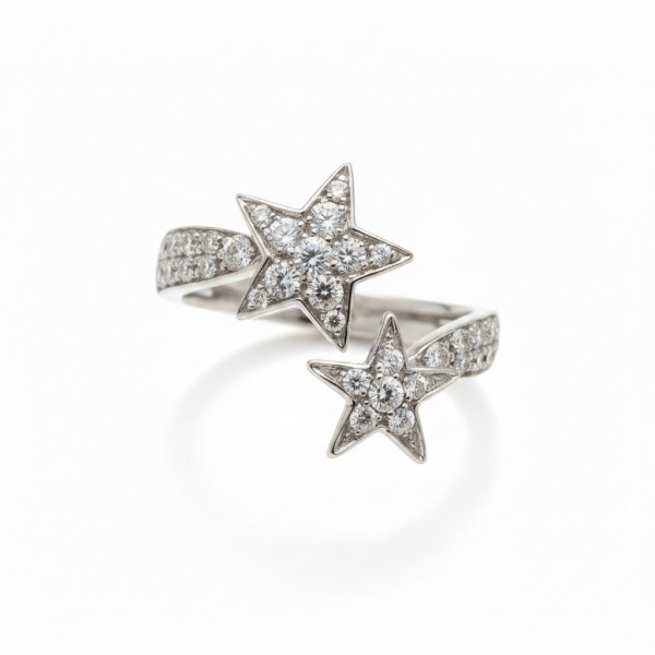Anel bypass em ouro branco 18k (750), pesando aproximadamente 6,98 g. Design aberto com duas estrelas de tamanhos distintos inteiramente cravejadas de brilhantes em pavê, totalizando cerca de 1,50 ct.