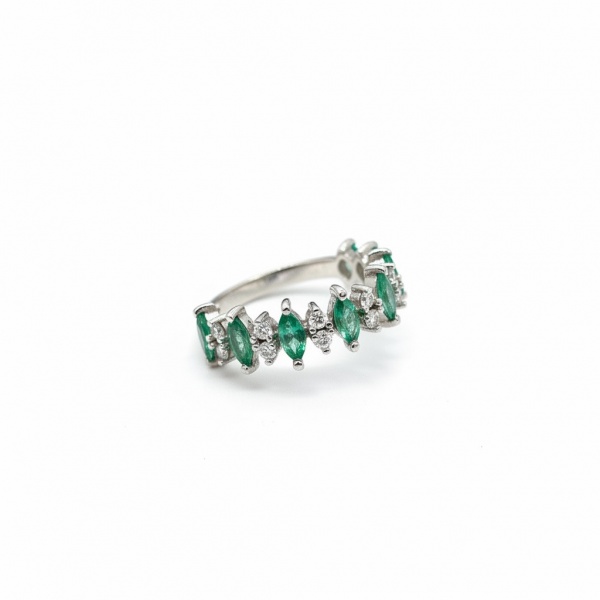 Meia aliança em ouro branco 18k, cravejada com esmeraldas naturais lapidação navete aproximadamente (50 pts) intercaladas com diamantes brilhantes aproximadamente (10 pts) em elegante composição zigue