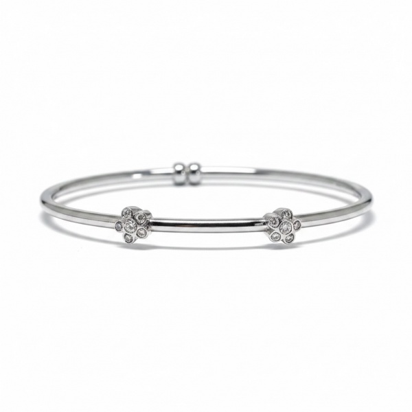Bracelete com dois módulos florais cravados com brilhantes redondos em cravação bezel. Total aproximadamente de 0,30 ct Peso 11,32 g Diâmetro 6,5 6,0 cm. Fechamento articulado.