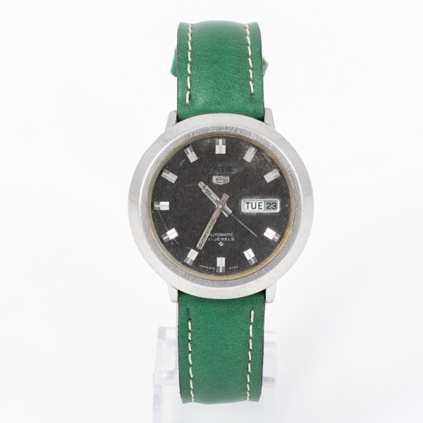 Relógio SEIKO 5 automático com mostrador preto com calendário diário e caixa de aço e pulseira de couro verde / Tam: 3,5cm - Sem garantias futuras
