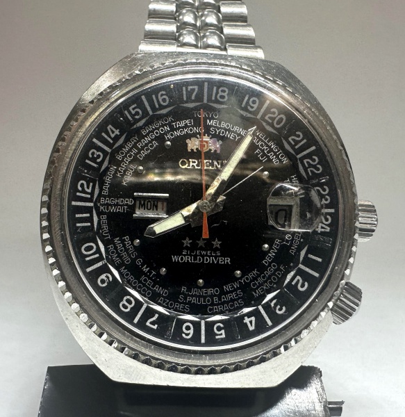 ORIENT - relógio de pulso, década de 70, masculino, automático, modelo World Driver, produzido em aço, mostrador diferenciado, coroas originais assinadas, vidro em acrílico com lente de aumento no cal